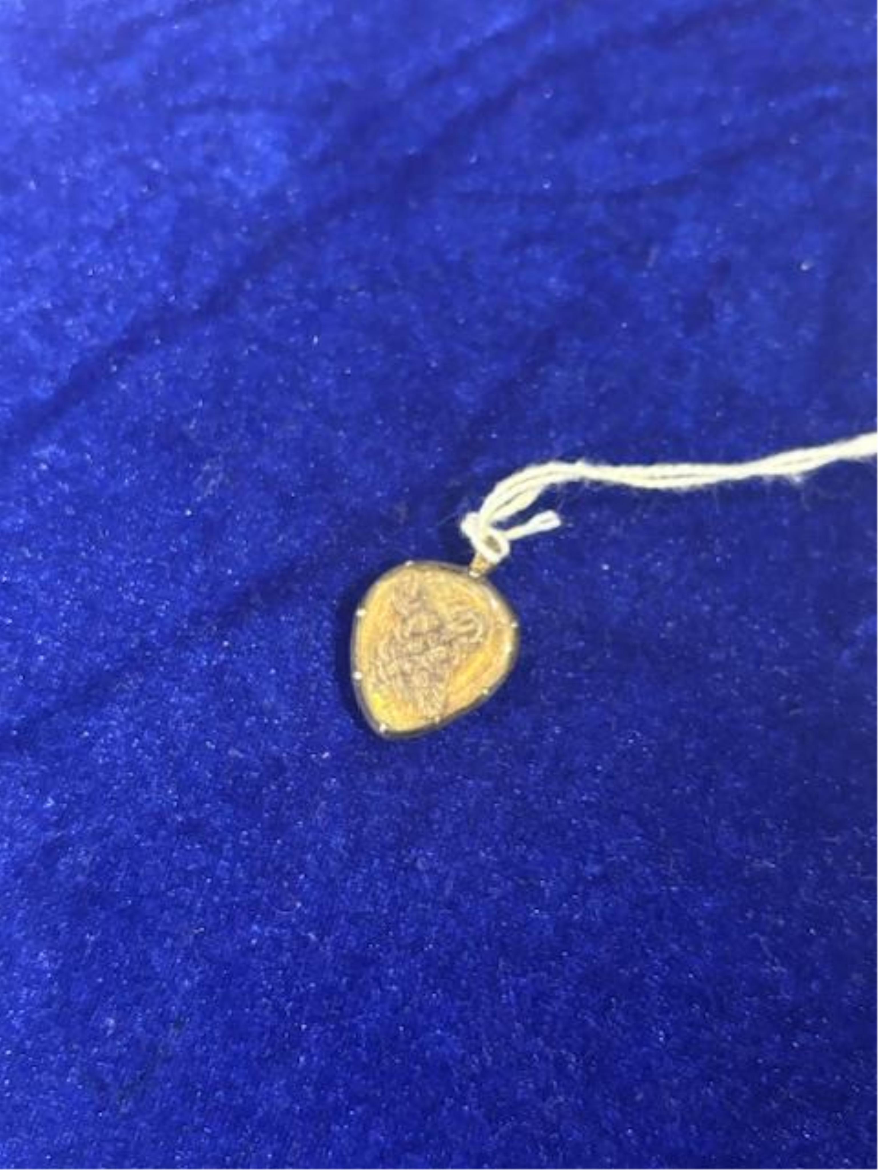 An 18th century gilt metal heart shaped mourning pendant, with engraved inscription, 'CARna DERBY DIED DEC 11th, 1762' and plaited hair beneath a glazed panel verso, 27mm.